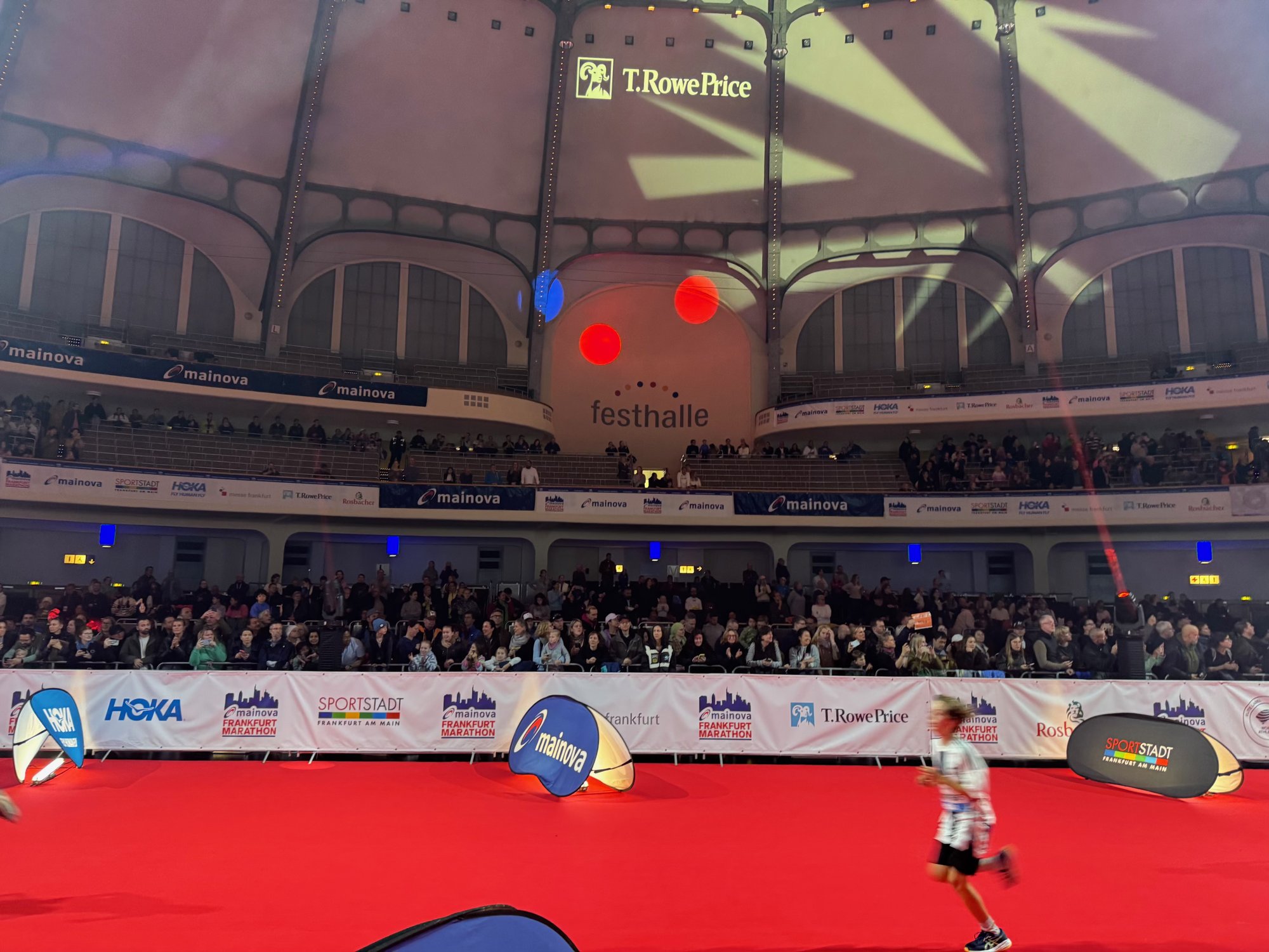 Ein Kind läuft auf dem roten Teppich in der vollen Frankfurter Festhalle ins Ziel